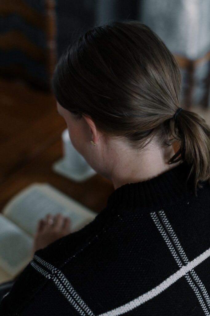 A woman sitting at a table reading a book